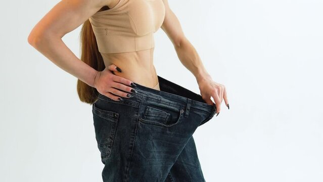 Woman in oversize jeans after weight loss, diet concept