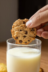 details and texture, holding a handmade chocolate chip cookie, dipping dessert into a glass of milk, delicious food and drink as wallpaper, treat