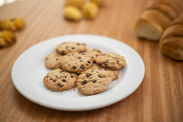 appetizing plate served with delicious homemade cookies decorated with chocolate chips, pastry shop in studio, sweet carbohydrate