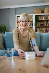 Senior caucasian woman check blood pressure measure device on hand