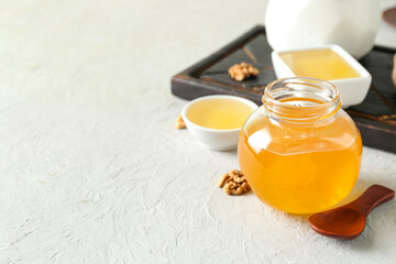 Jar of sweet honey on light background