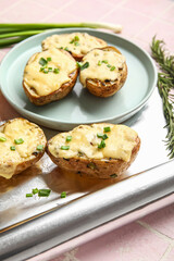 Tasty baked potato with cheese and aluminium foil roll on color tile background, closeup