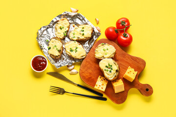 Composition with tasty baked potato, cheese, tomatoes and sauce on yellow background