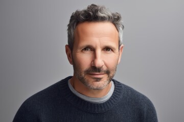 Obraz premium Handsome middle-aged man with grey hair and beard looking at camera