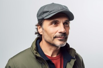 Portrait of a man in a cap and a green jacket on a gray background