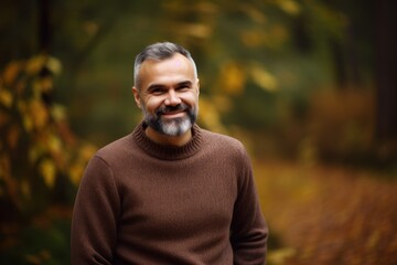Portrait of a smiling middle-aged man in the autumn forest