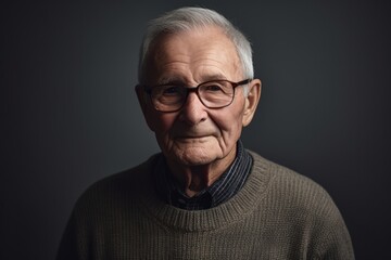 Obraz premium Portrait of an old man with glasses on a dark background.