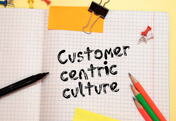 Text CUSTOMER CENTRICITY on white paper on clipboard with chart and calculator.