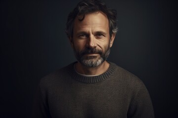 Obraz premium Portrait of a middle-aged man in a sweater on a dark background