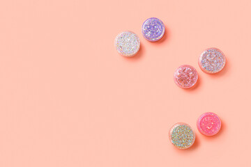 Jars of glitter on pink background
