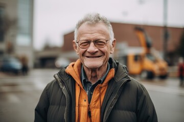 portrait of smiling senior man in eyeglasses standing on street
