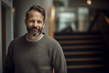 Fototapeta premium Portrait of a handsome middle-aged man with gray hair and beard in a gray sweater
