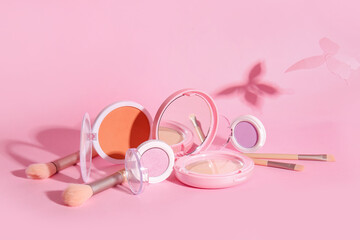 Obraz na płótnie Canvas Decorative cosmetics with makeup brushes on pink background