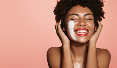 portrait of sensual black woman, gently touching her soft, healthy face with facial cream, skincare product on cheek, using lotion or daily care for better skin tone, pink background