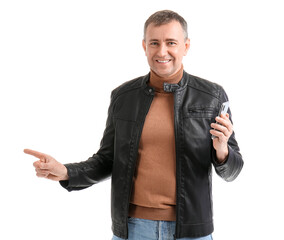 Mature man with mobile phone pointing at something on white background