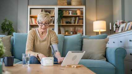 Senior caucasian woman check blood pressure measure device on hand