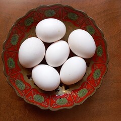 Sei uova bianche nel centrotavola in rame