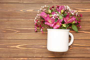 Cup with beautiful flowers on wooden background
