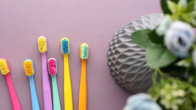  colorful toothbrushes on purple color background 