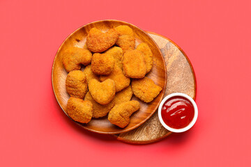 Plates of tasty nuggets and ketchup on red background