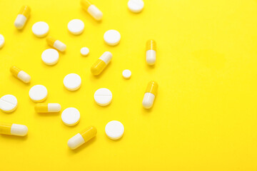 Different pills on yellow background, closeup