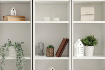 Bookcase with artificial plants and decor in room