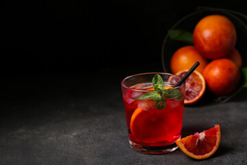 Glass of tasty blood orange lemonade on dark background