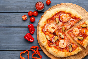 Plate of tasty seafood pizza on blue wooden background
