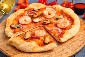 Plate of tasty seafood pizza on blue wooden background