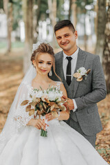 bride and groom on the background of a fairy-tale forest. Royal wedding concept. the groom embraces...
