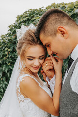 Fototapeta premium bride and groom in the garden among greenery. Royal wedding concept. Gorgeous dress of the bride. Tenderness and calmness. Portrait photography
