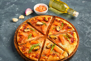 Plate of tasty seafood pizza on blue background