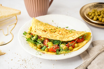 Tasty omelet with vegetables on light background