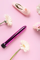 Vibrators with gerbera flowers on pink background