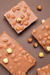 Sweet tasty chocolate with nuts on  brown background