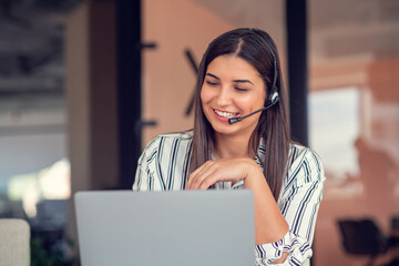 Young friendly operator woman agent with headsets working in a call centre.