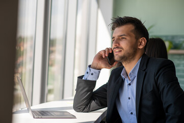 Young businessman talking on the phone at the office