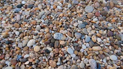 Smooth round pebbles on beach in Portugal. Natural background texture.