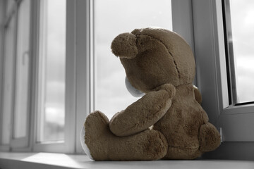 Cute teddy bear on windowsill indoors. Space for text