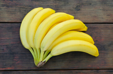 Bunch of ripe yellow bananas on wooden table, top view