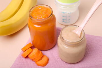 Healthy baby food, spoon and ingredients on pale pink background