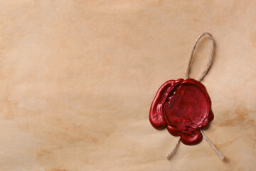 Sheet of old parchment paper with wax stamp as background, top view. Space for text
