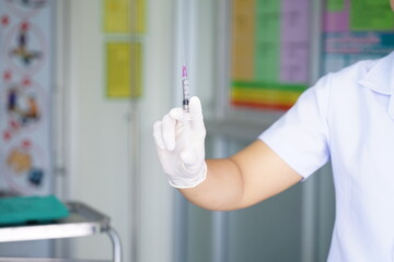 The doctor prepares a syringe.