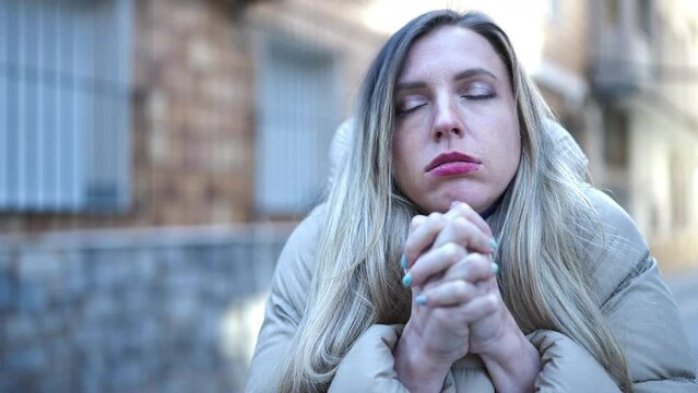 Young blonde woman rubbing hands for cold at street