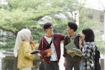A group of diverse, multiracial young Asian university students are seen resting and chatting...