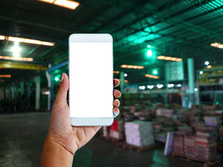 hand and smartphone and warehouse blurry background