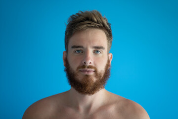 portrait of a young handsome man without clothes on a blue background