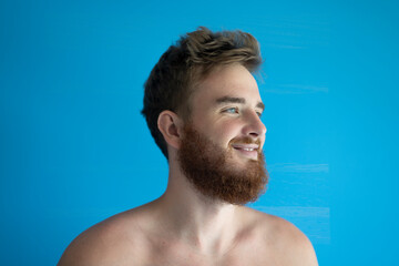 portrait of a young handsome man without clothes on a blue background