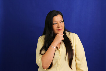 Adult Latino woman in his forties appears pensive and thoughtful