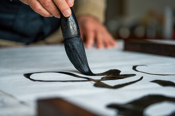 An old Chinese calligrapher is creating and writing calligraphy works.
Translation: carry on the past and open up the future. - obrazy, fototapety, plakaty